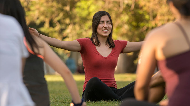 A woman leads an outdoor yoga class