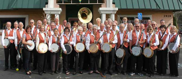 About three dozen members of the Sacramento Banjo Band holding their banjos and wearing red-and-white striped vests, white shirts and black pants.