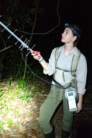 A woman holds a tracking device at night