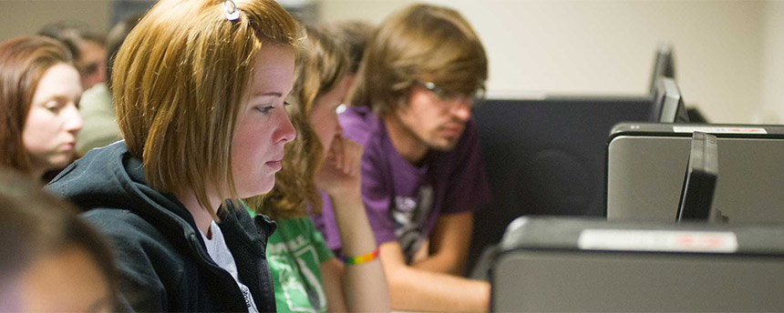 A row of students at computers working