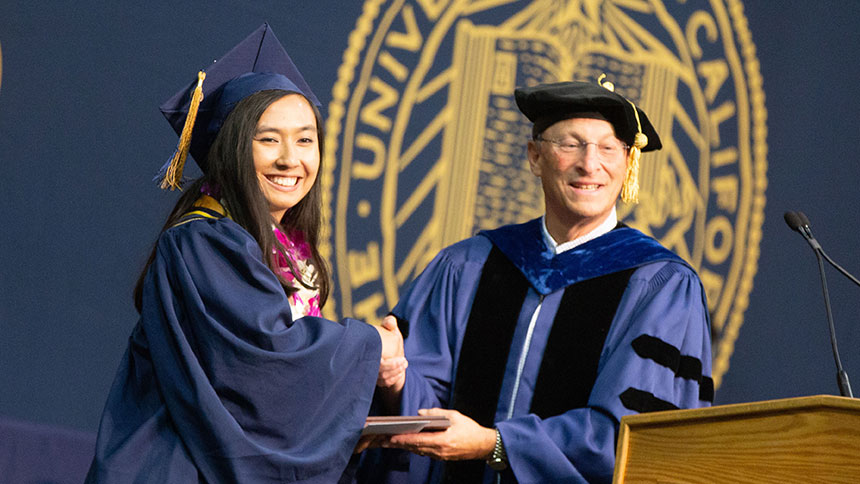 Ralph Hexter, provost and executive vice chancellor, presents an award to Emily Eijansantos at  commencement