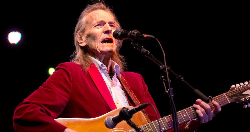 Gordon Lightfoot singing on stage and playing guitar.