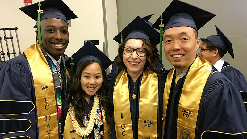 Four graduates pose at School fo medicine commencement