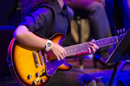 A closeup of someone playing an electric guitar.