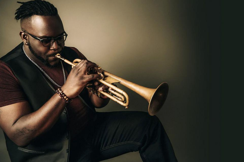 A photo of Marquis Hill playing the trumpet.