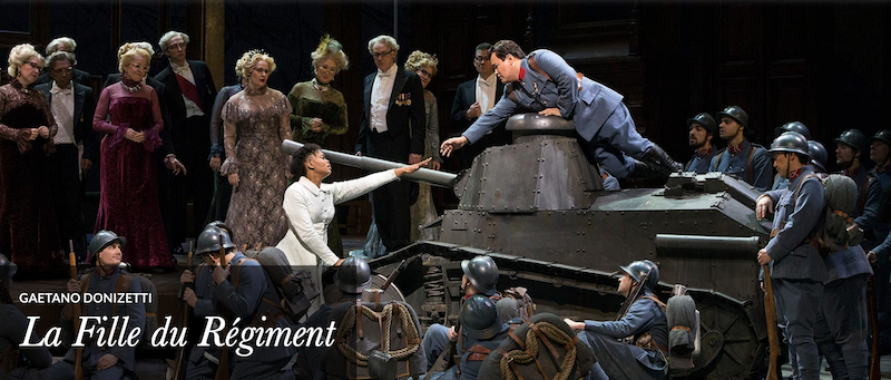 The company performing the opera on stage with a tank.