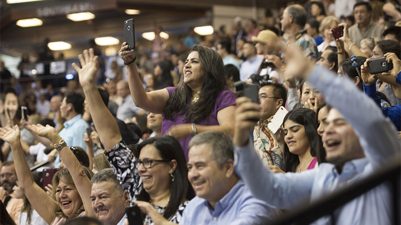 Family members cheer at a commencement ceremony. 