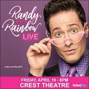 Randy Rainbow holding his pink frame reading glasses on the tip of his nose.