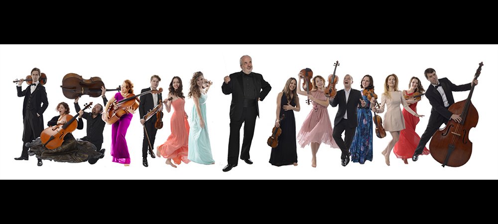 The members of the Russian String Orchestra dressed in formal wear, exhuberantly dancing against a white background, holding their instruments.