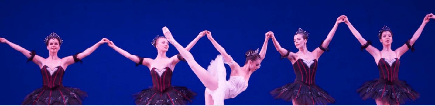 A photo of a prima ballerina backed by four other ballerinas.