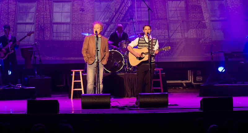 A photo of the actors playing Simon and Garfunkel on stage.