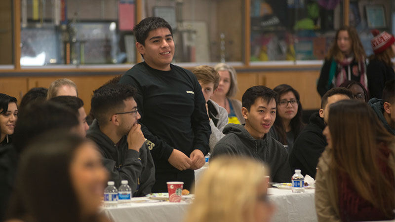 A boy stands among fellow students