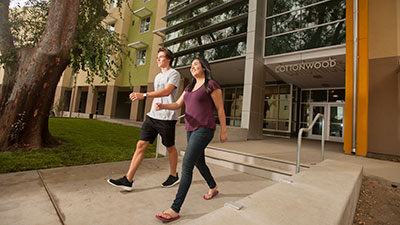 Two students walk in front of Cottonwood Hall