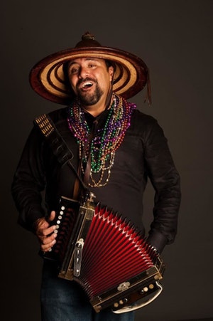 A photo of Terrance Simien holding an accordion.