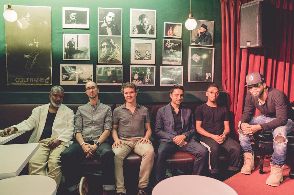 Members of the sextet sitting in a jazz club.